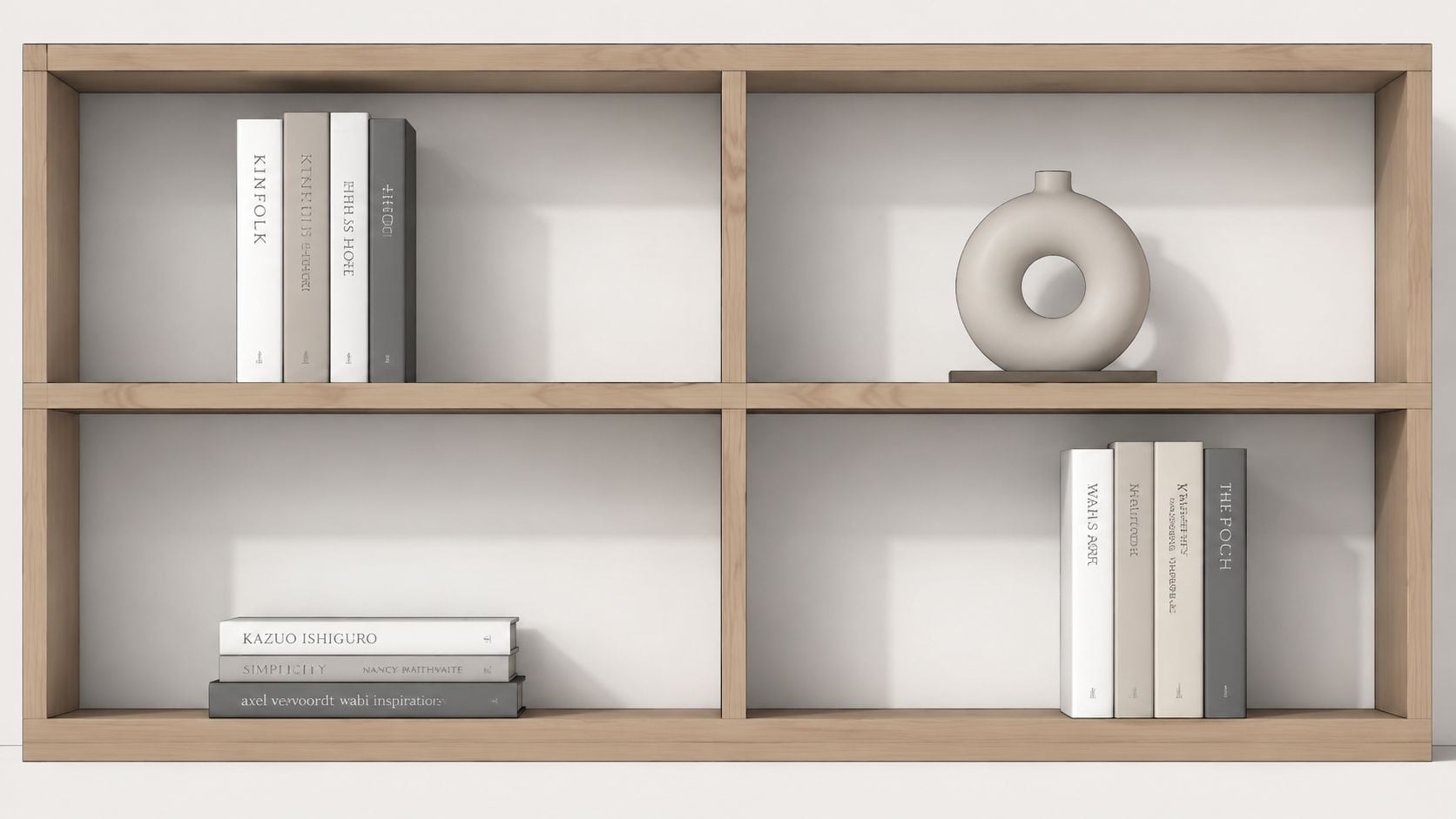 A modern light wood bookshelf featuring minimalist decor, including stacked books and a circular ceramic vase.